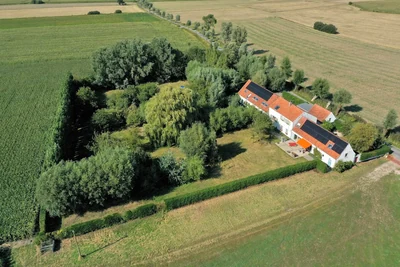 Luchtfoto van Polderlicht: het huis met rode daken en de tuin tussen de polders